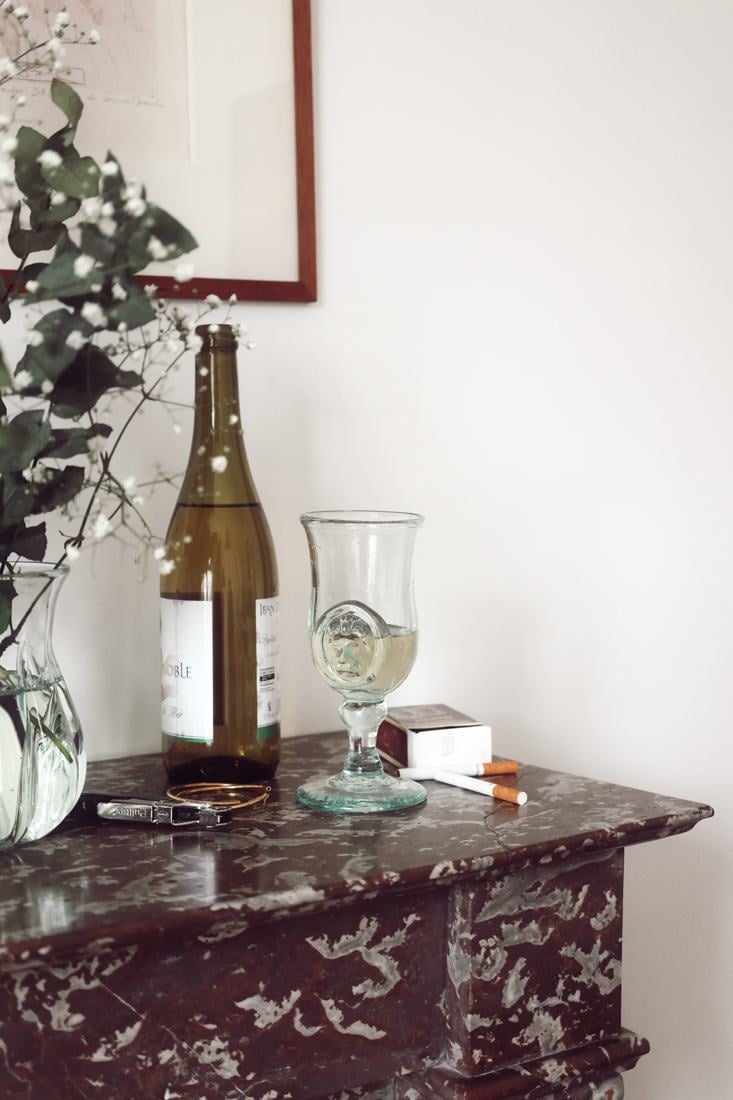 Tiki Lion with white wine on a marble mantelpiece